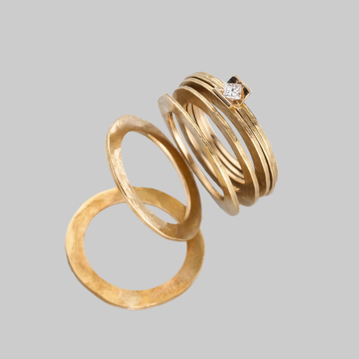 Handgeschmiedeter Scheibchenring aus 7 einzelnen 750er-Gelbgoldscheiben aus recyceltem Gold, teils gehämmert, teils glatt, mit einem eingefassten Brillanten – individuelles Unikat.