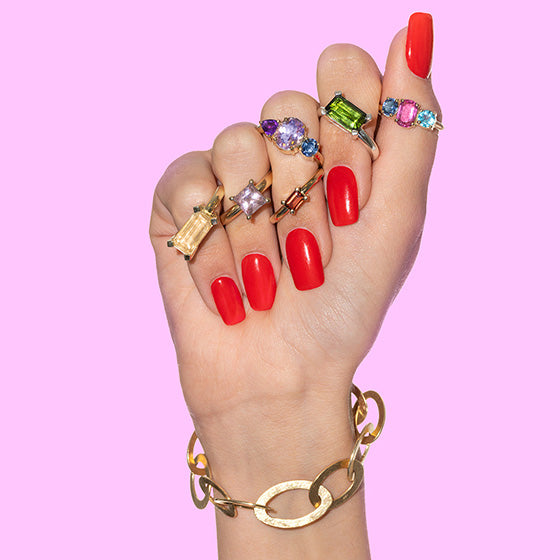Atelier Q Geschenkgutschein mit Schmuckhand und bunten Ringen