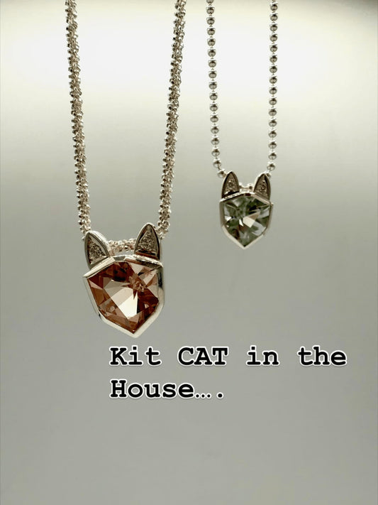 Zwei hängende Katzenanhänger aus 925 Silber, jeweils mit facettiertem Edelstein und kleinen Brillanten in den Ohren, an silbernen Kugelketten – Schmuckdesign Atelier Q.