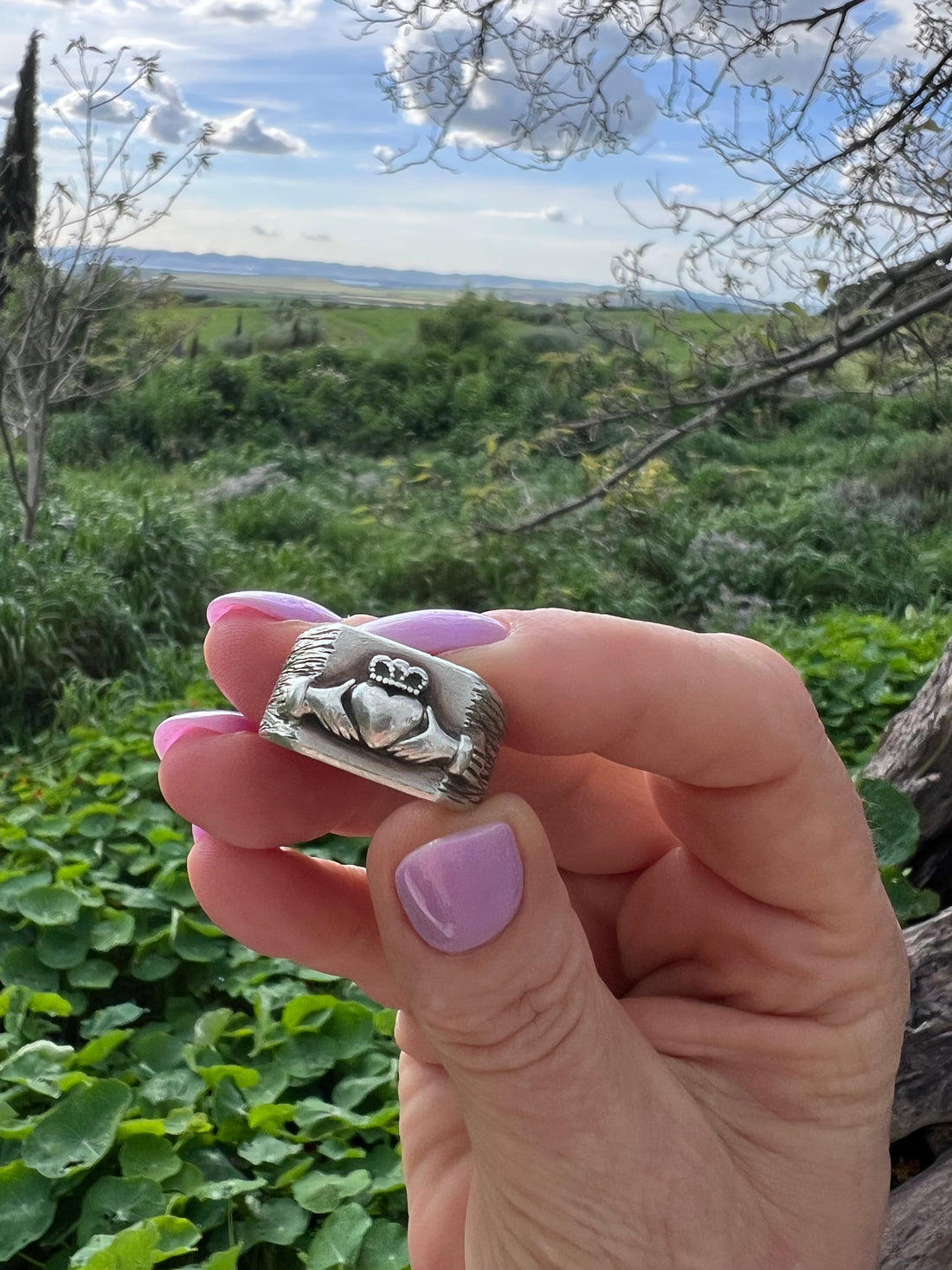 Hand hält einen massiven Claddagh Ring aus Silber – Herz, Hände und Krone als Symbol für Liebe, Freundschaft und Treue, handgeschmiedet im Atelier Q Köln