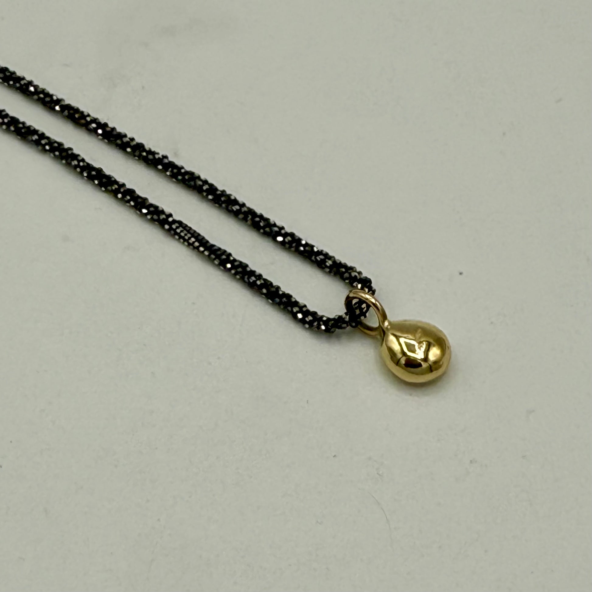 Nugget aus Altgold in leichter Tropfenform an einer gekordelten Silber geschwärzten Kette. Handarebit