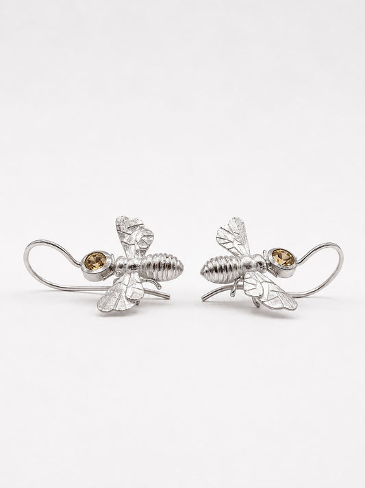 Ein Paar handgefertigter Bienen Ohrhänger aus 925 Silber, 
einander zugewandt – Detailansicht der strukturierten Oberfläche, 
Flügel und hellgelben Citrine – Einzelstück Atelier Q Köln.