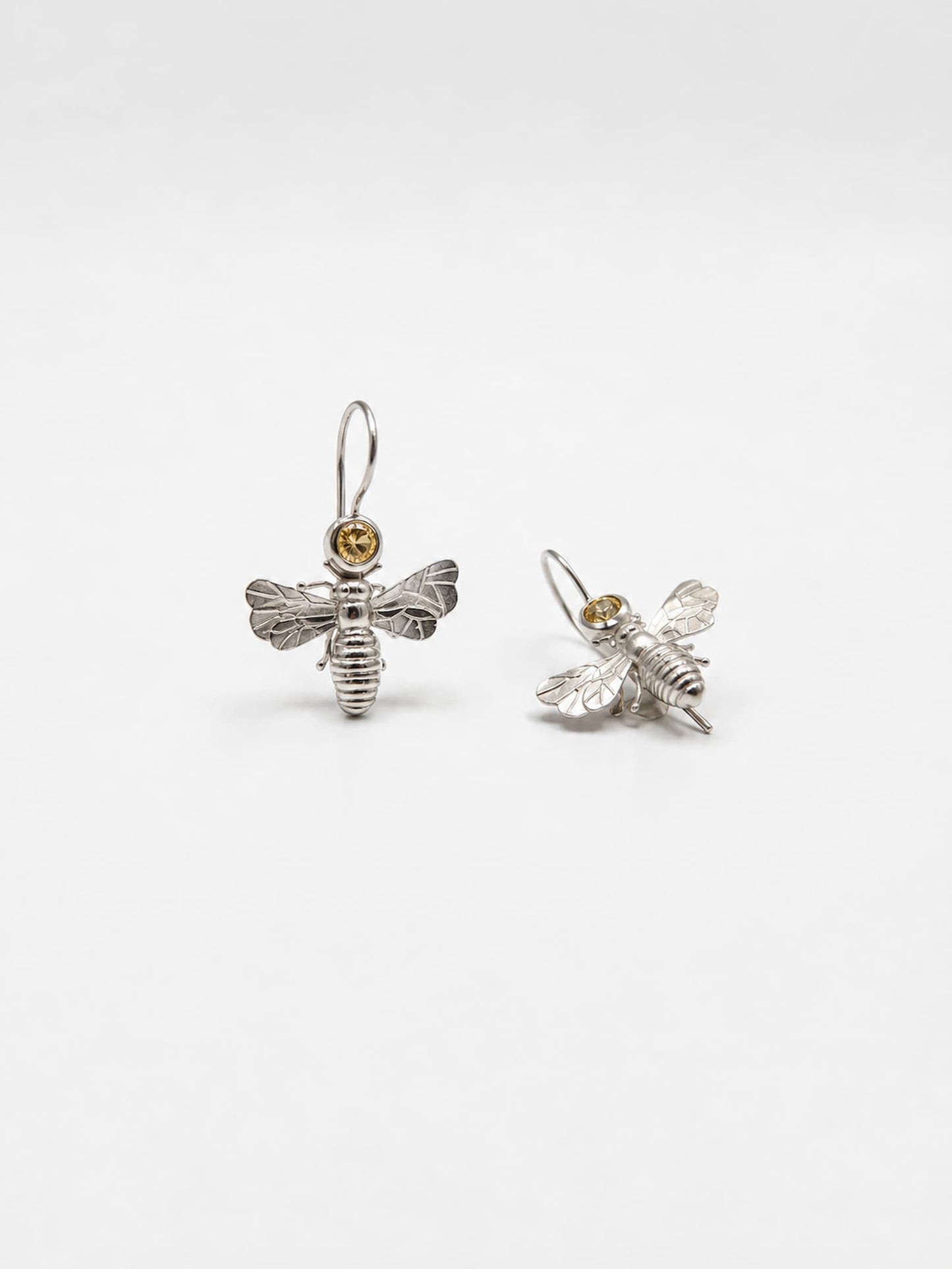 Handgefertigte Bienen Ohrhänger aus 925 Silber von vorne – 
sichtbare Flügelstruktur, gerippter Körper und hellgelber Citrin 
in runder Zargenfassung – Atelier Q Köln.