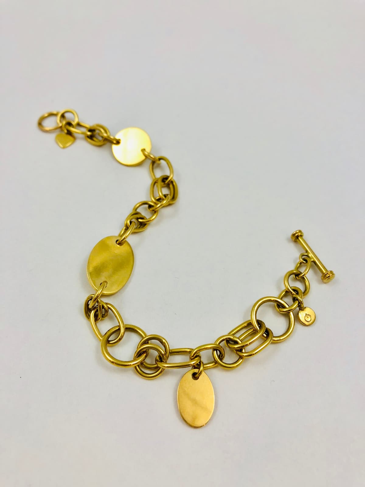 Massiv handgeschmiedetes Ösenarmband aus recyceltem Gold mit unterschiedlich großen runden und ovalen Ösen, dazu kleine eingearbeitete Plättchen – hochwertiges Unikat aus dem Atelier Q