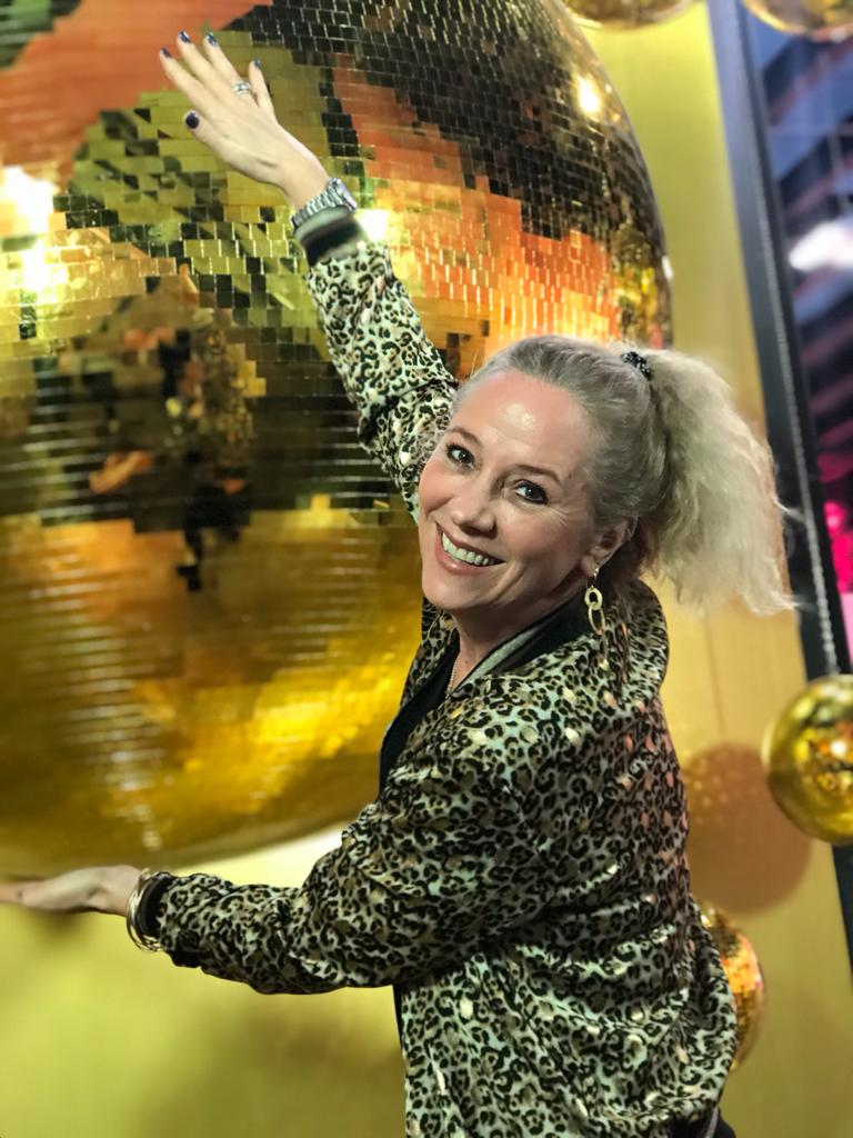 Inhaberin von Atelier Q bei einem Disco-Event mit goldenen Lichteffekten