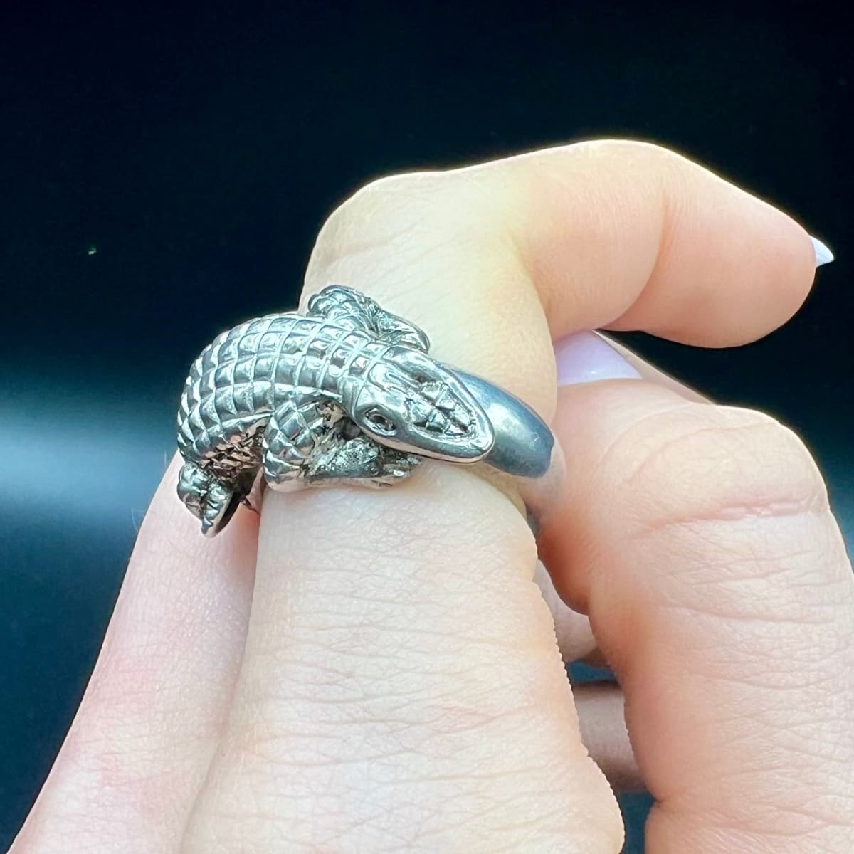 Silberner Krokodil-Ring am Zeigefinger getragen mit plastisch ausgearbeitetem Kopf und Körper – handgefertigtes Schmuckunikat aus dem Atelier Q.