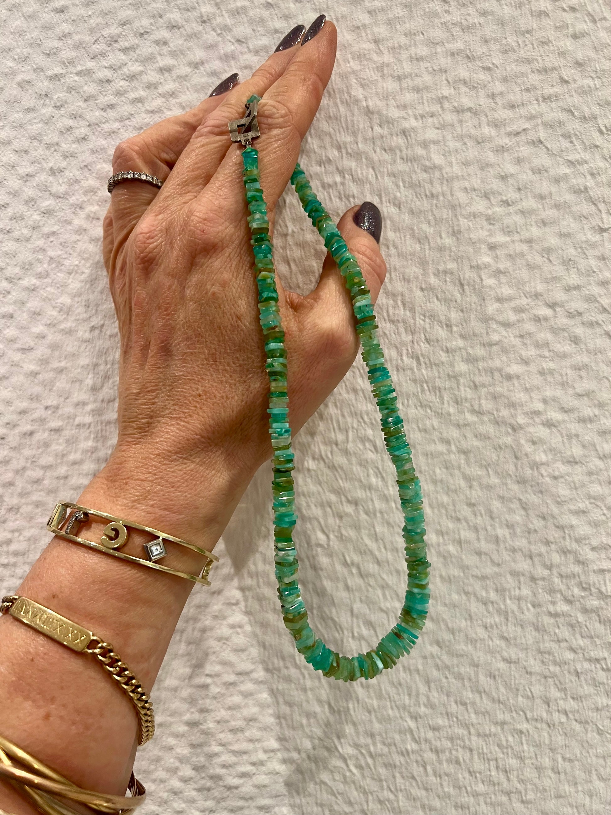 Hand hält die Opalkette – Schmuck aus 585er Weißgold