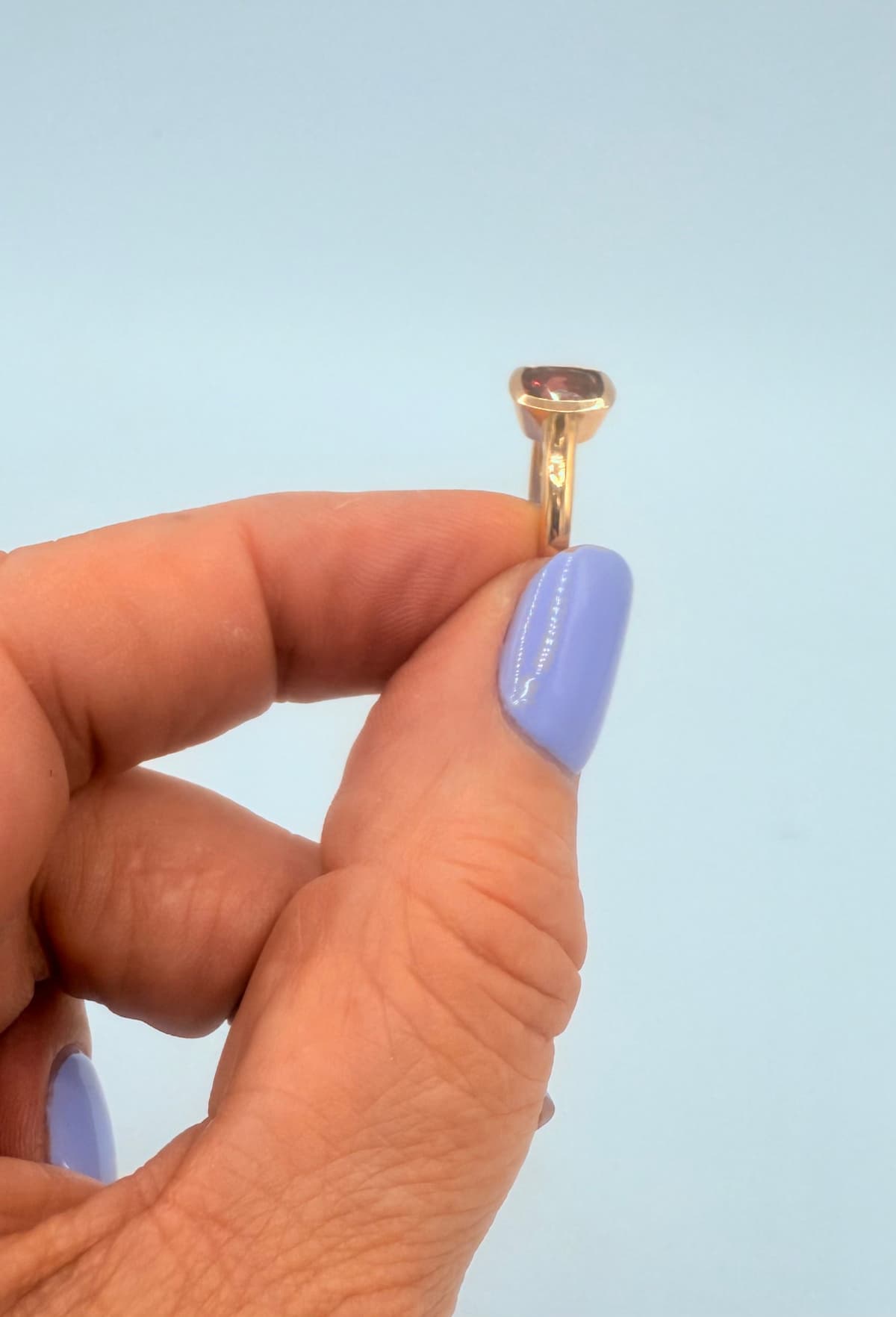 Ring Cube Red – getragen am Finger, 585 Gelbgold mit antik geschliffenem Granat aus recycelten Gold.