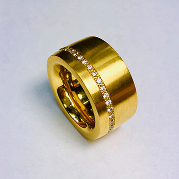 Breiter Goldring aus 750/000 Gelbgold – massives Design, kombiniert mit liegendem Memory-Ring aus Diamanten, handgefertigt im Atelier Q aus Altgold. Familienschmuck umgearbeitet.