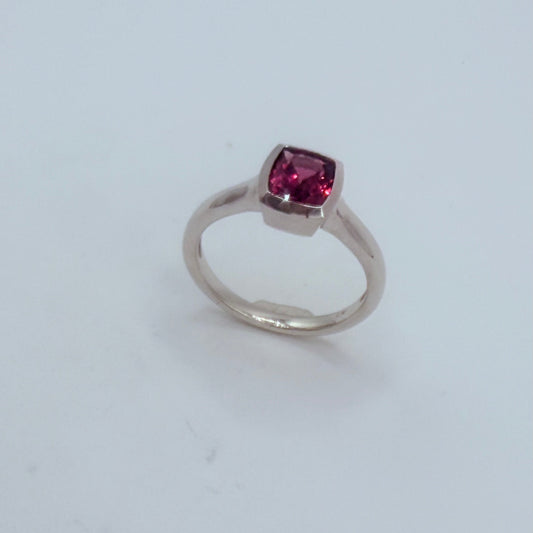 Solitär-Ring Q aus Platin mit facettiertem Rhodolit – Vorderansicht auf weißem Hintergrund.Unikatschmuck